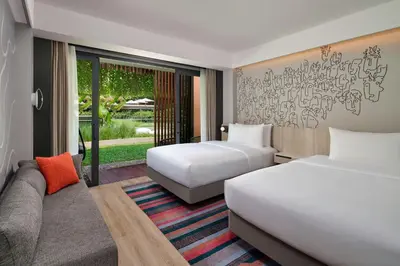 a hotel room with two beds and a couch at Aloft Bali Kuta at Beachwalk in Kuta