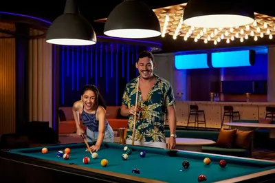 a man and a woman standing next to a pool table at Aloft Bali Kuta at Beachwalk in Kuta