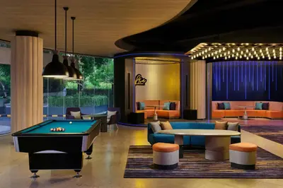 a lobby with a pool table and couches at Aloft Bali Kuta at Beachwalk in Kuta