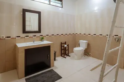 a bathroom with a toilet and a sink and a mirror at Villa Penny, Seminyak - Spacious 3 Bedroom Pool Villa! in Seminyak