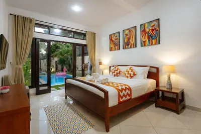a bedroom with a bed and a pool at Villa Penny, Seminyak - Spacious 3 Bedroom Pool Villa! in Seminyak