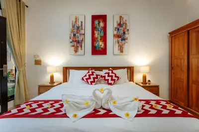 a bedroom with a white bed with two swans on it at Villa Penny, Seminyak - Spacious 3 Bedroom Pool Villa! in Seminyak