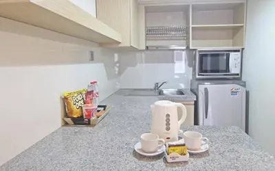 a kitchen with a counter with two cups and a sink at The Legian Sunset Residence in Seminyak