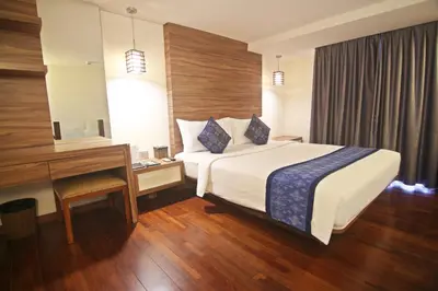 a hotel room with a bed and a desk at The Legian Sunset Residence in Seminyak