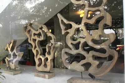 a group of wooden sculptures in a store window at The Legian Sunset Residence in Seminyak