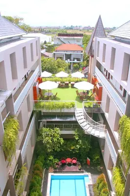 an aerial view of a building with a pool and tables and umbrellas at The Legian Sunset Residence in Seminyak