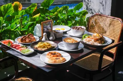 a table with plates of food on top of it at Kayumas Seminyak Resort in Seminyak