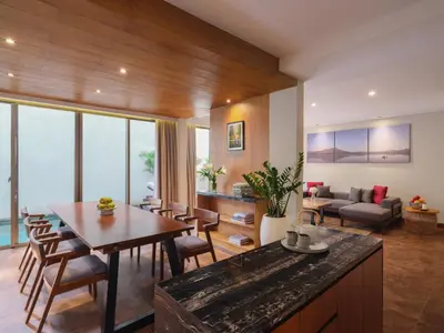 a kitchen and living room with a table and chairs at Kayumas Seminyak Resort in Seminyak