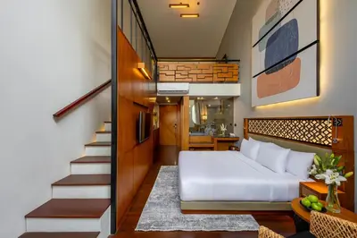 a bedroom with a bed and a stair case at Kayumas Seminyak Resort in Seminyak