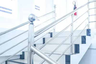 a set of stairs in a building with a metal railing at KoolKost at Bypass Jimbaran - Minimum Stay 30 Nights in Kuta