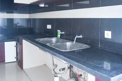 a kitchen with a sink and a black counter top at KoolKost at Bypass Jimbaran - Minimum Stay 30 Nights in Kuta