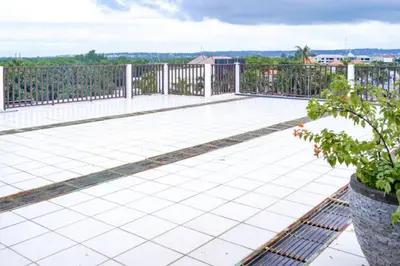 a patio with white tiles and a fence at KoolKost at Bypass Jimbaran - Minimum Stay 30 Nights in Kuta
