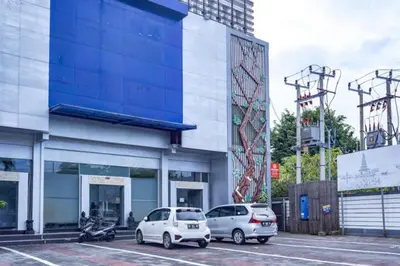 two cars parked in a parking lot in front of a building at KoolKost at Bypass Jimbaran - Minimum Stay 30 Nights in Kuta