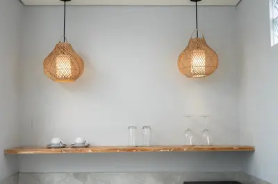 two pendant lights hanging over a wooden shelf at The Eight Villa & Rooms Bali - Seminyak in Seminyak