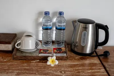 a table with two bottles of water and a kettle at The Eight Villa & Rooms Bali - Seminyak in Seminyak