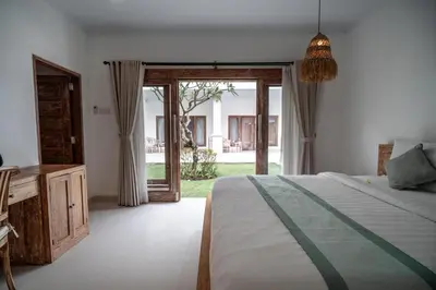 a bedroom with a bed and a sliding glass door at The Eight Villa & Rooms Bali - Seminyak in Seminyak