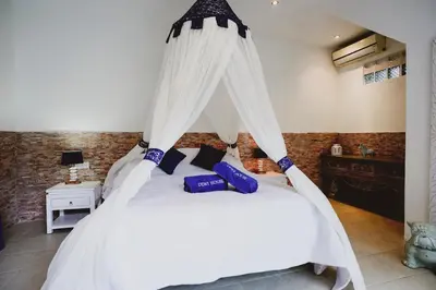 a bedroom with a white bed with a canopy at Villa Dewi in Seminyak