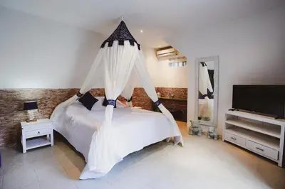 a bedroom with a bed with mosquito netting at Villa Dewi in Seminyak