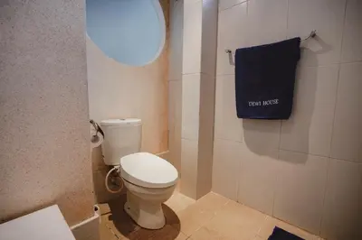 a bathroom with a toilet and a blue towel at Villa Dewi in Seminyak