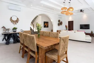 a dining room with a wooden table and chairs at Villa Besakih in Canggu