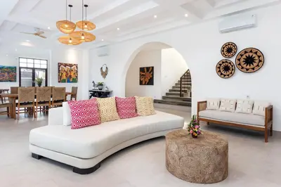 a living room with a white couch with colorful pillows at Villa Besakih in Canggu
