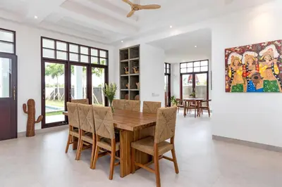 a dining room with a wooden table and chairs at Villa Besakih in Canggu