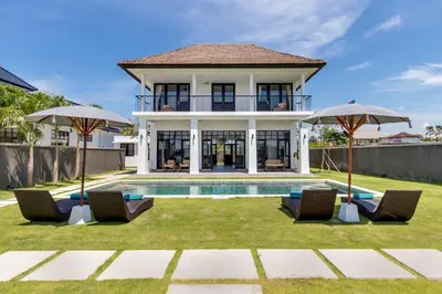 a house with a swimming pool and two umbrellas at Villa Sakayana 4BR Canggu in Canggu