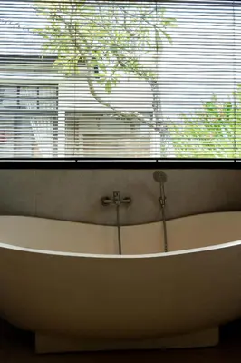 a bath tub sitting under a window in a bathroom at Villa Sakayana 4BR Canggu in Canggu