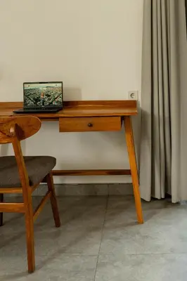 a wooden desk with a laptop sitting on top of it at Villa Sakayana 4BR Canggu in Canggu