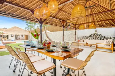 an outdoor dining area with a wooden table and chairs at Villa Toscana - 7 BDR Luxury Villa with private pool in Seminyak