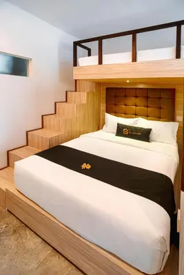 a bedroom with a bunk bed with a staircase at Graha Socio Hotel Nusa Dua Bali in Nusa Dua