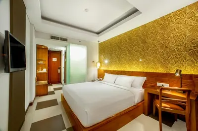 a bedroom with a white bed and a yellow wall at Sun Island Hotel & Spa Legian in Legian