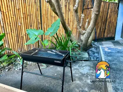 a barbecue grill sitting in front of a fence at Villa di Sawah - by Unicorn Villas Bali in Kerobokan