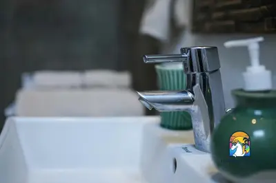 a bathroom sink with a green faucet on a counter at Villa di Sawah - by Unicorn Villas Bali in Kerobokan