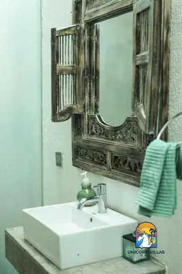 a bathroom with a white sink and a mirror at Villa di Sawah - by Unicorn Villas Bali in Kerobokan
