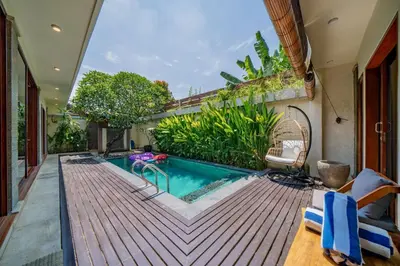 a swimming pool on a deck next to a house at Villa Paradise Seminyak in Seminyak
