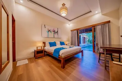 a bedroom with a bed and a table and a piano at Villa Paradise Seminyak in Seminyak