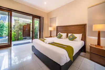 a bedroom with a large bed and a large window at Villa Kinawa Seminyak in Seminyak