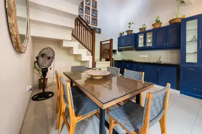 a dining room with a wooden table and blue cabinets at Villa Kinawa Seminyak in Seminyak