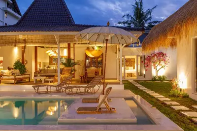 a house with a swimming pool and an umbrella at Villa M2 Seminyak by Alfred in Bali in Seminyak