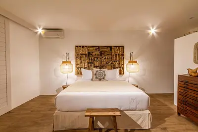 a bedroom with a large bed and two lamps at Villa M2 Seminyak by Alfred in Bali in Seminyak