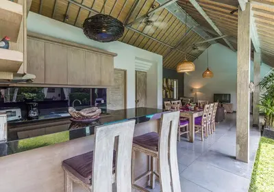 an open kitchen and dining room with a table and chairs at VILLA Nuri Merah 2 in Seminyak