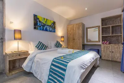 a bedroom with a bed and a mirror on the wall at VILLA Nuri Merah 2 in Seminyak
