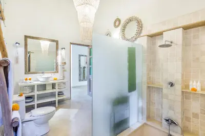 a bathroom with a shower and a toilet and a sink at Villa 007 in Seminyak
