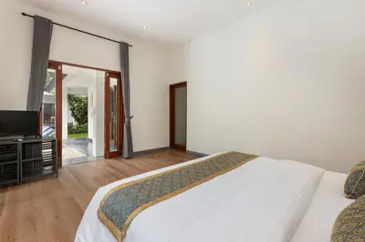 a bedroom with a bed and a flat screen tv at Andaman Umalas by Kerta Living in Canggu