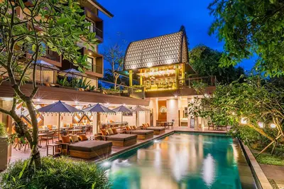 a hotel with a swimming pool in front of a building at Pandawa All Suites Hotel in Seminyak