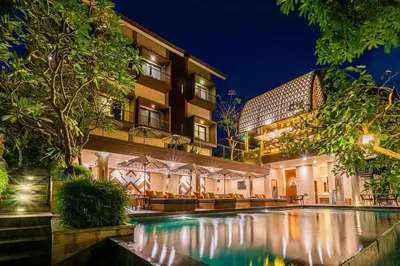 a hotel with a swimming pool in front of a building at Pandawa All Suites Hotel in Seminyak