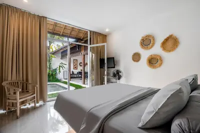 a bedroom with a bed and a sliding glass door at Villa Baik Baik by BaliSuperHost in Seminyak