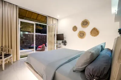 a bedroom with a bed with blue pillows on it at Villa Baik Baik by BaliSuperHost in Seminyak