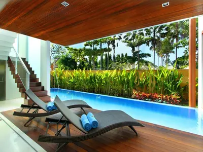 two chairs and a swimming pool in a house at Papillon Umalas Villas in Canggu